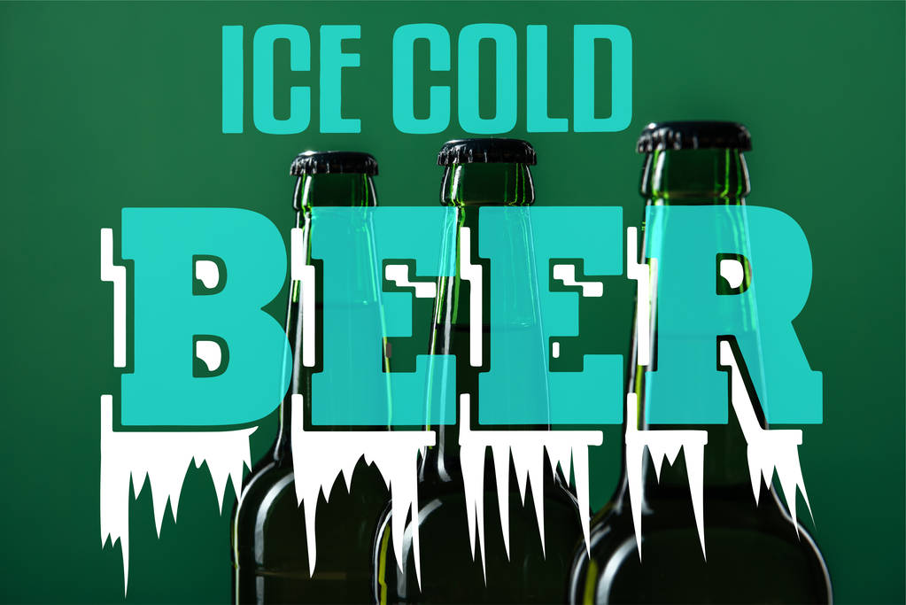 Bierflaschen neben eiskaltem Bier Schriftzug auf grünem Hintergrund - Foto, Bild