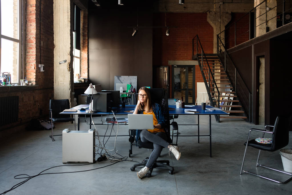Uma menina trabalha em um computador em um escritório moderno
 - Foto, Imagem
