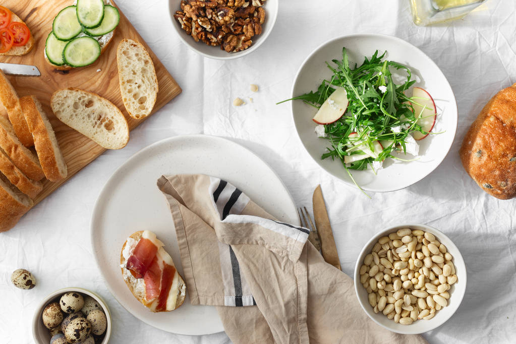 Gezond ontbijt lunch snack broodjes prosciutto groenten rucola salade achtergrond bovenaanzicht - Foto, afbeelding