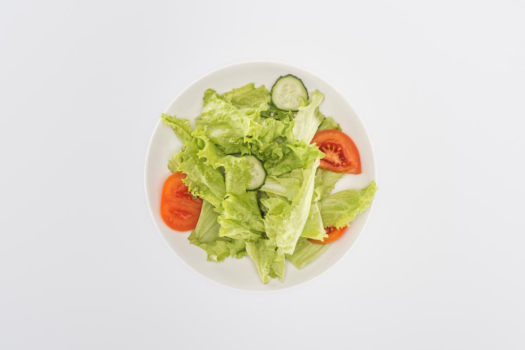 bovenaanzicht van gehakte salade op plaat geïsoleerd op wit - Foto, afbeelding