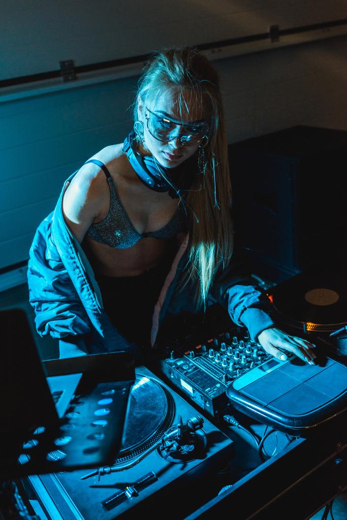 Geballte DJ-Frau in Gläsern neben DJ-Mischpult  - Foto, Bild