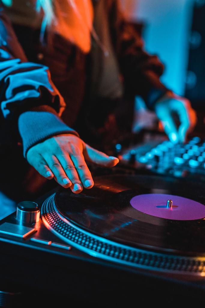 Ausgeschnittene Ansicht von DJ-Frau berührt Schallplatte in Nachtclub - Foto, Bild
