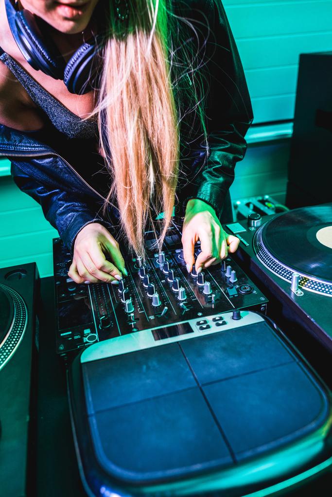 vista ritagliata di dj ragazza toccando equalizzatore sul mixer dj in discoteca
  - Foto, immagini