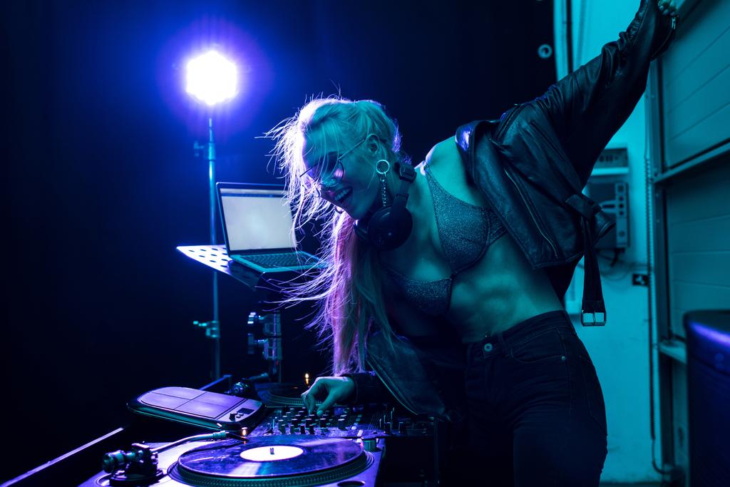 Krásná blondýna dj dívka se dotýká dj mixer stoje v nočním klubu  - Fotografie, Obrázek