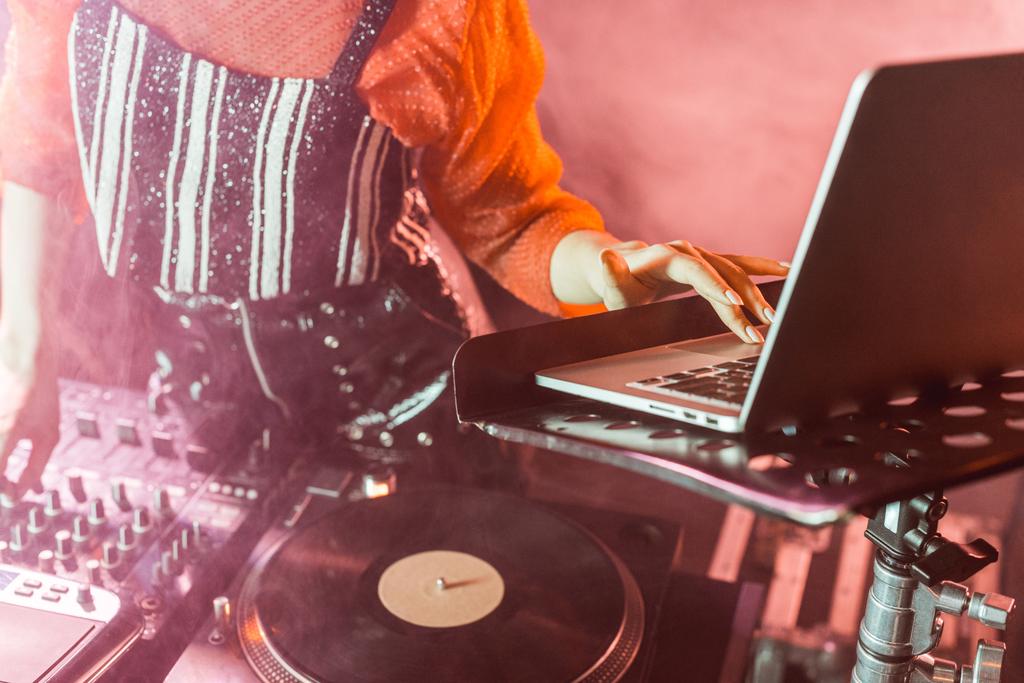 vista ritagliata di dj ragazza utilizzando il computer portatile in discoteca con fumo
  - Foto, immagini