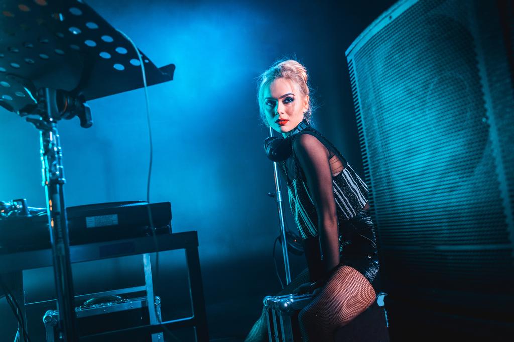 blonde élégante dj femme dans les écouteurs debout dans la boîte de nuit
 - Photo, image