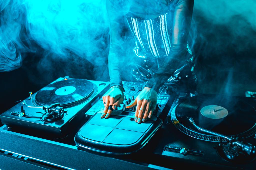 recortado vista de dj mujer utilizando dj equipo en discoteca con humo
 - Foto, imagen
