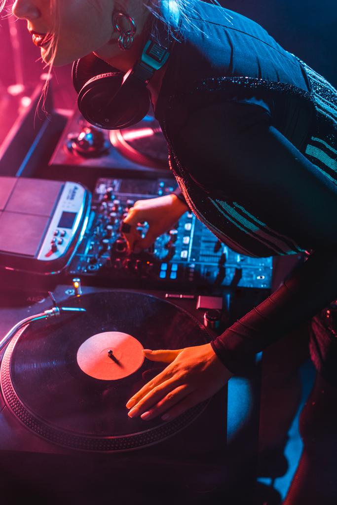 Ausgeschnittene Ansicht fokussierter Dj-Frau mit DJ-Ausrüstung in Nachtclub   - Foto, Bild