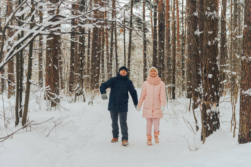 Una pareja amorosa camina por el bosque. Paseo familiar en el bosque de invierno
 - Foto, imagen