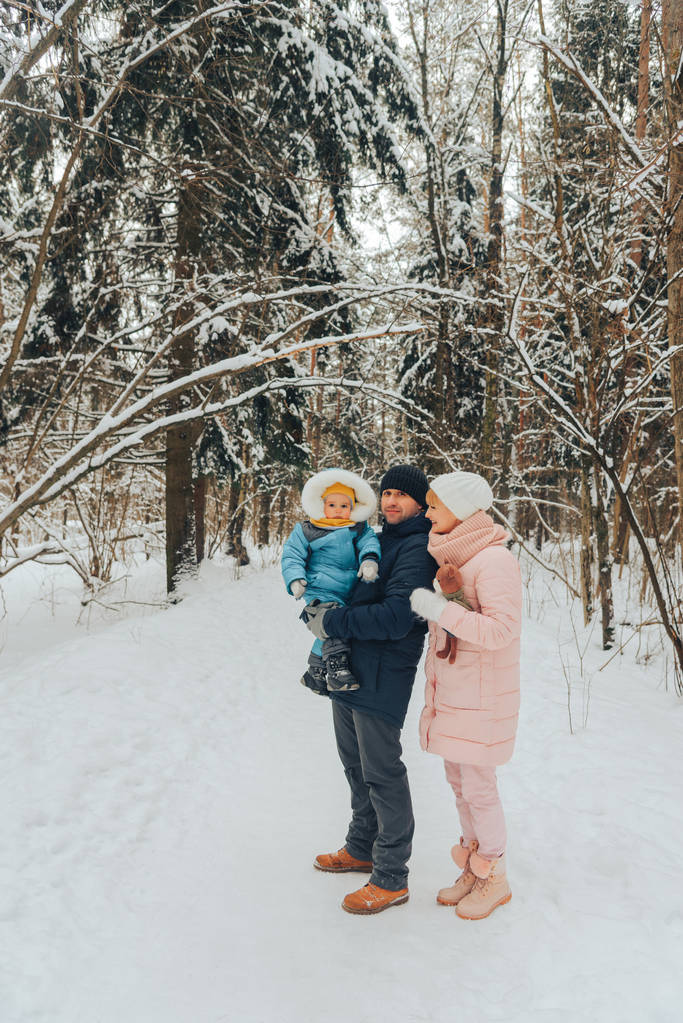 子どもをもつ家族を歩きます。冬の自然の中で家族散歩。冬の自然の家族の散歩。雪がたくさん. - 写真・画像