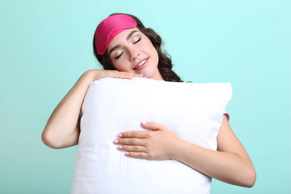 Menina bonita com máscara de dormir e travesseiro branco na hortelã backg
 - Foto, Imagem