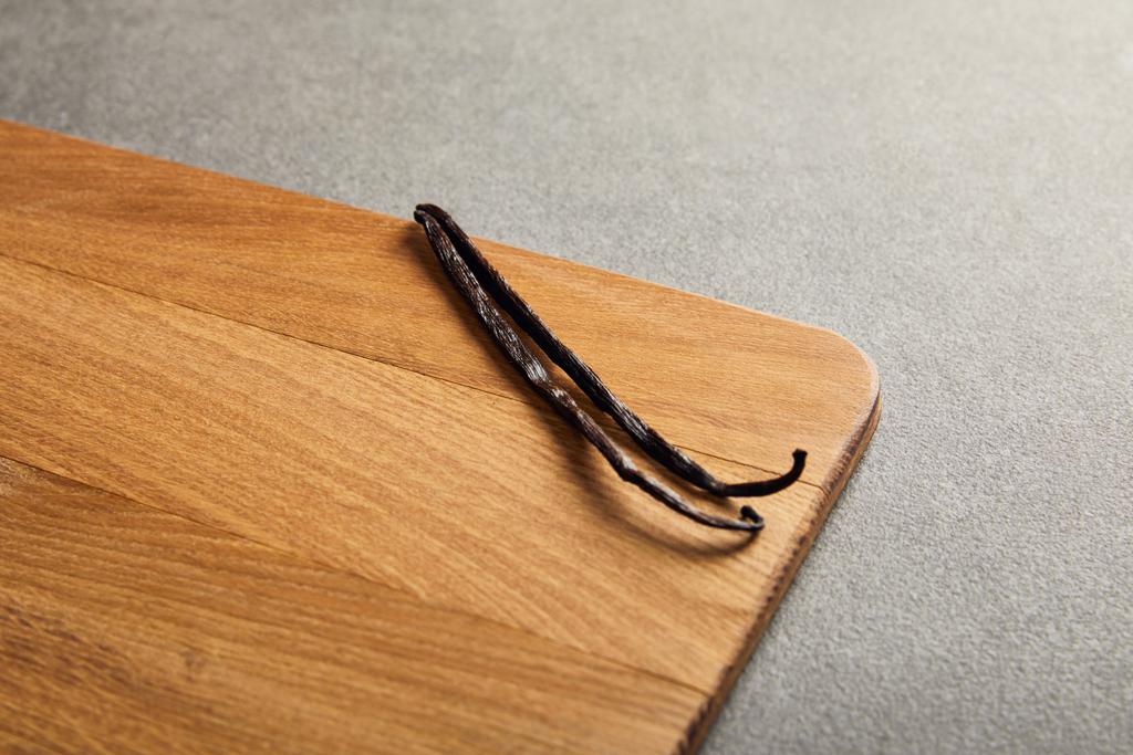 Vanilya pods ahşap kesme tahtası koyu yüzeyinde yatan  - Fotoğraf, Görsel