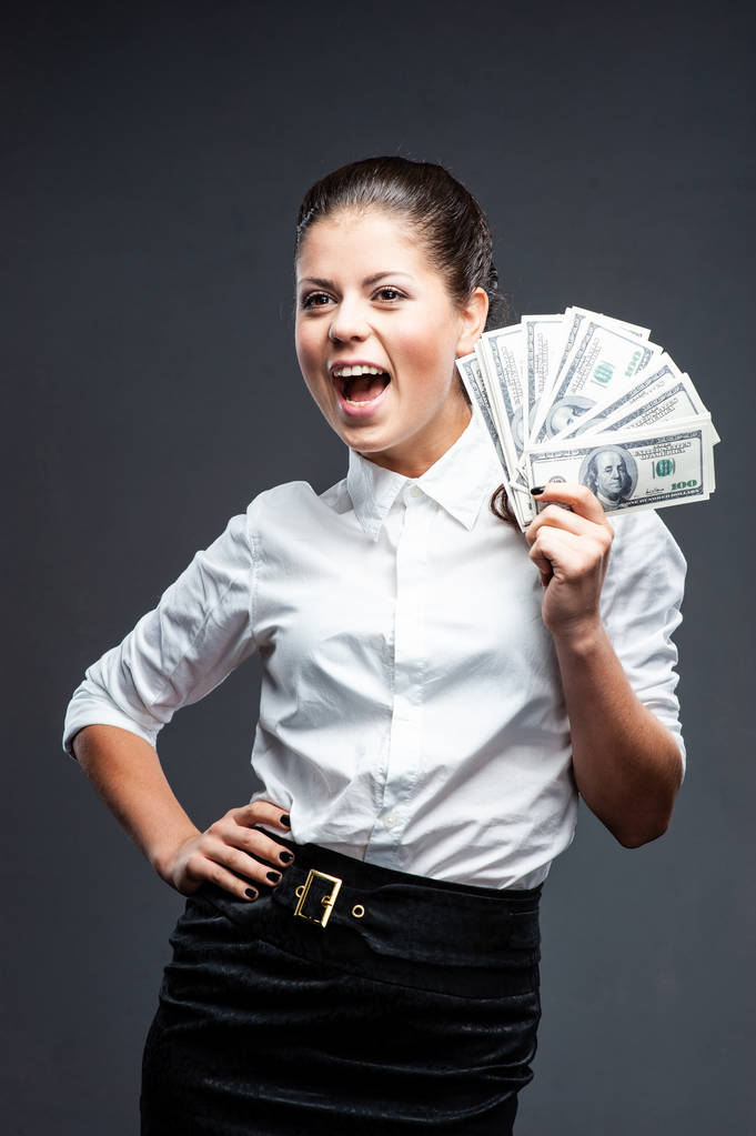   alegre mujer de negocios caucásica en traje negro celebración de dinero
 - Foto, imagen