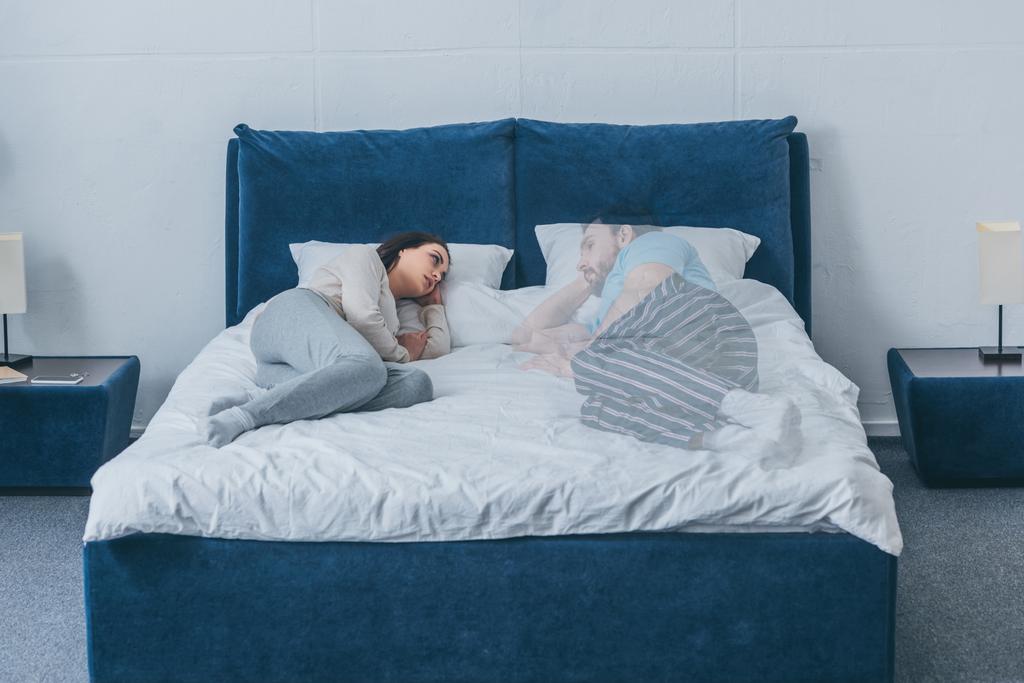 depressed woman lying in bed and looking at husband ghost - Photo, Image