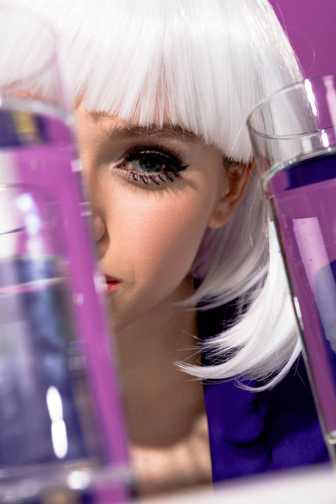 Девушка в белом парике с стаканами воды на фиолетовом фоне
 - Фото, изображение