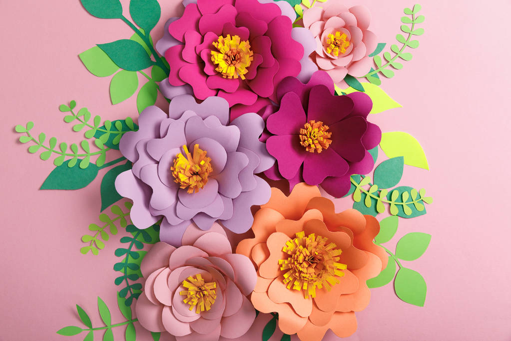 felülnézet, papír virágok, zöld és sárga levelek rózsaszín háttér  - Fotó, kép