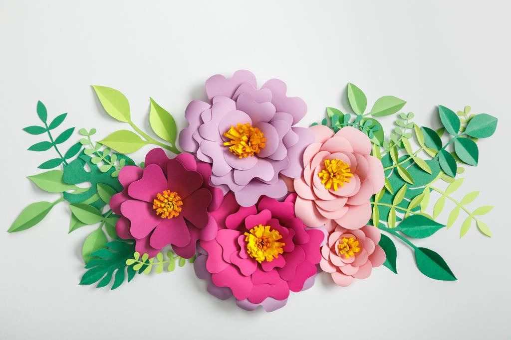 Widok z góry różowy i fioletowy papier kwiatów z zielonych liści na szarym tle - Zdjęcie, obraz
