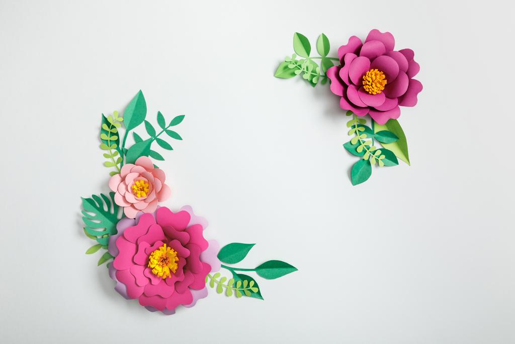 top view of paper flowers and green plants with leaves on grey background - Photo, Image