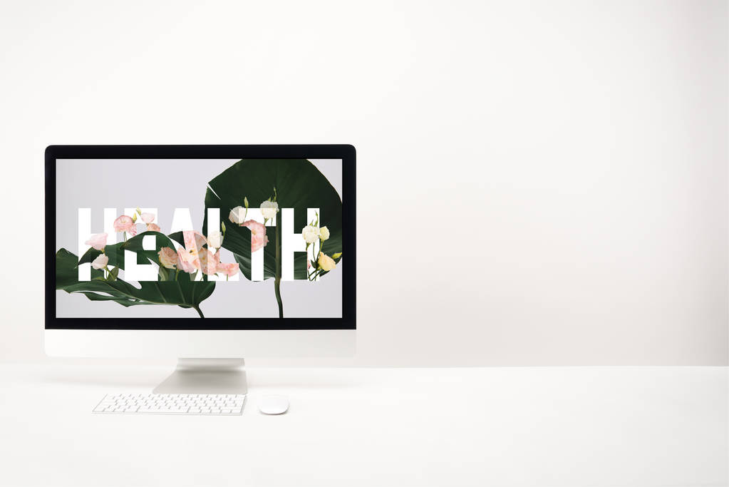 ordenador con letras de salud y hojas de monstera verde en el monitor sobre fondo blanco
 - Foto, imagen