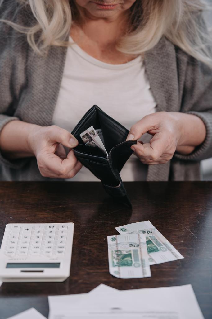 περικοπεί άποψη των ανώτερων γυναίκα που κρατά το πορτοφόλι με τα χρήματα  - Φωτογραφία, εικόνα