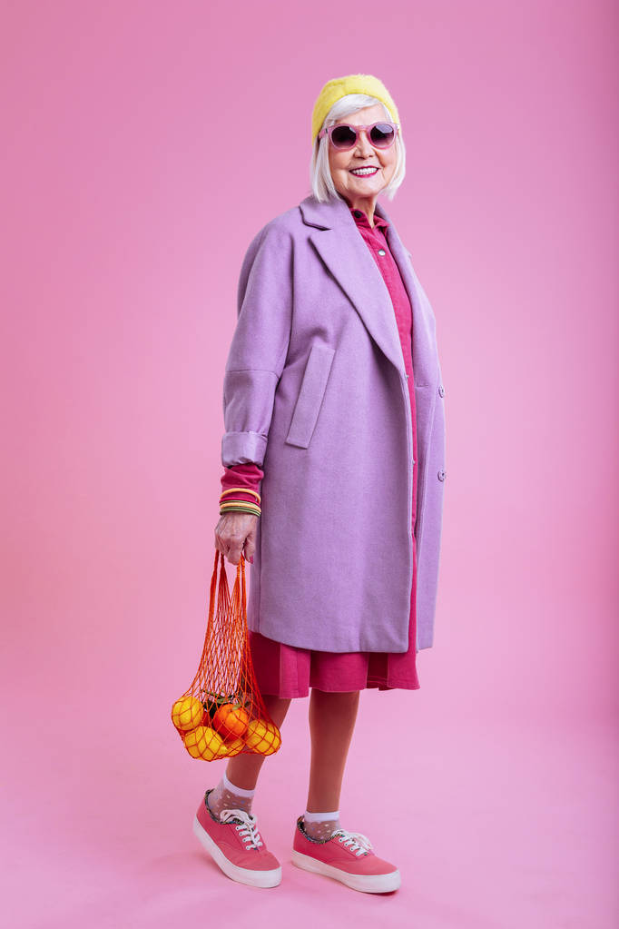 Radiante abuela amorosa caminando con frutas a los nietos
 - Foto, imagen