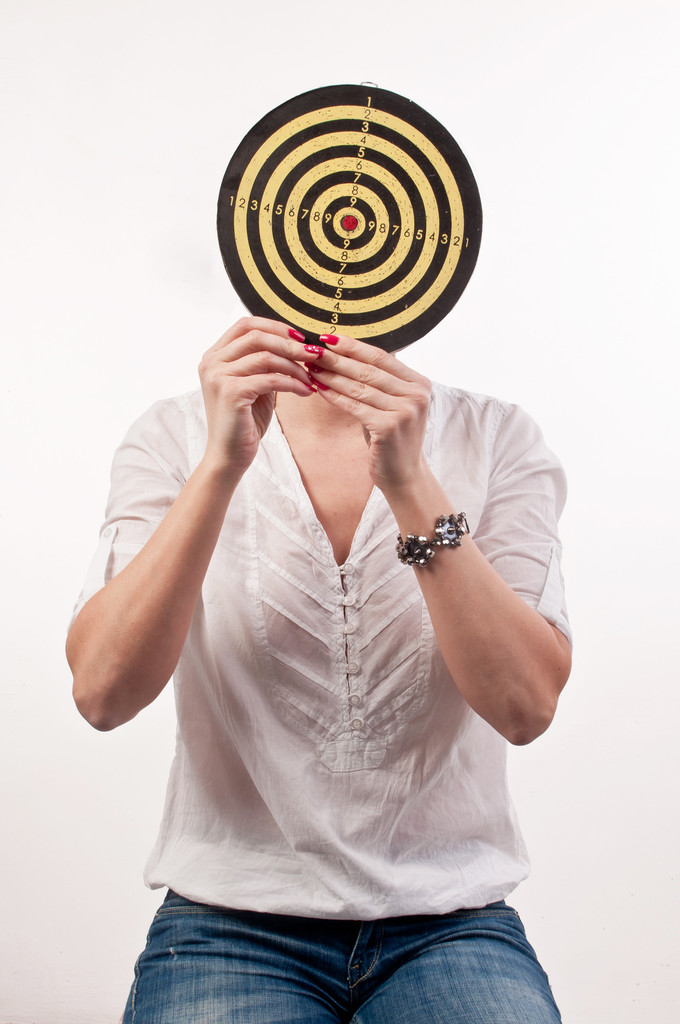 Young woman with dartboard in front of face, Bull's Eye - Photo, Image