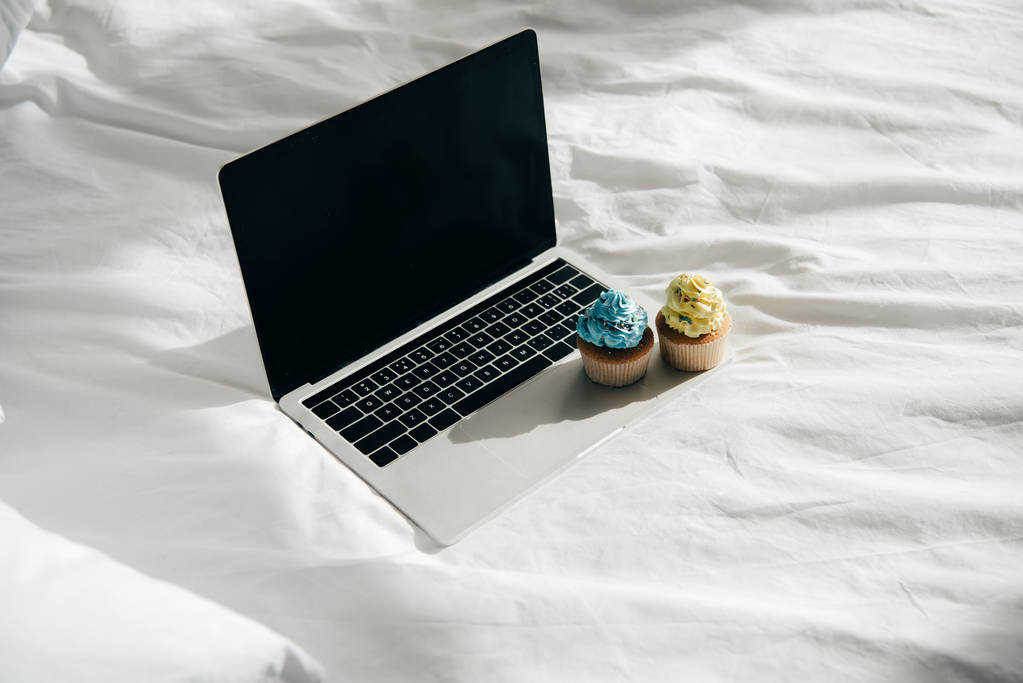 солодкі і смачні кекси на ноутбуці з порожнім екраном
  - Фото, зображення