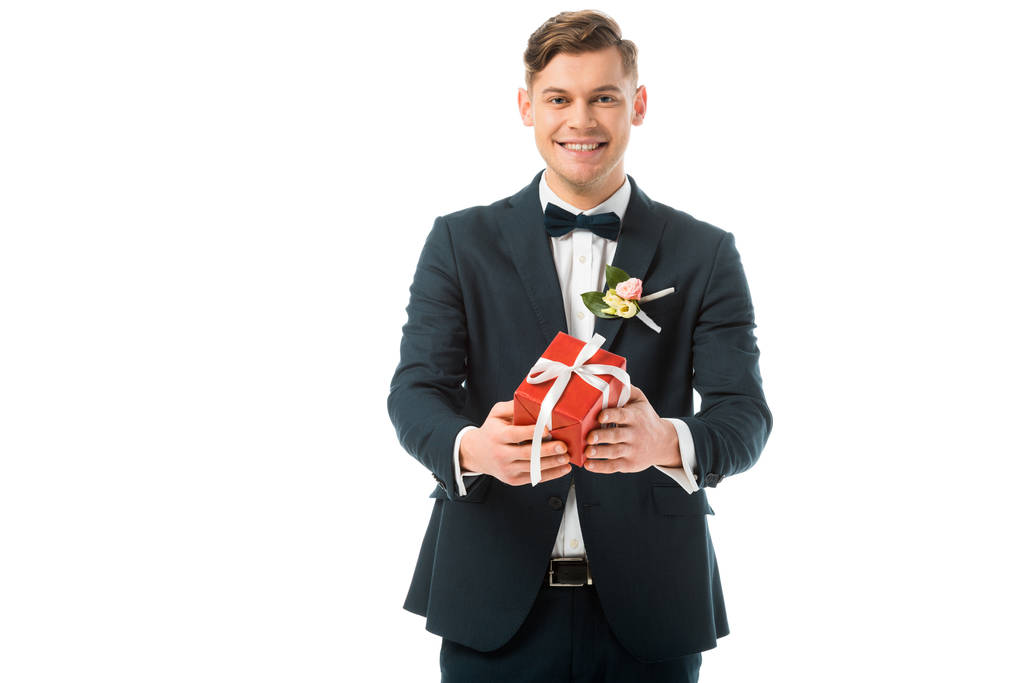 novio feliz sosteniendo caja de regalo roja aislada en blanco
 - Foto, Imagen