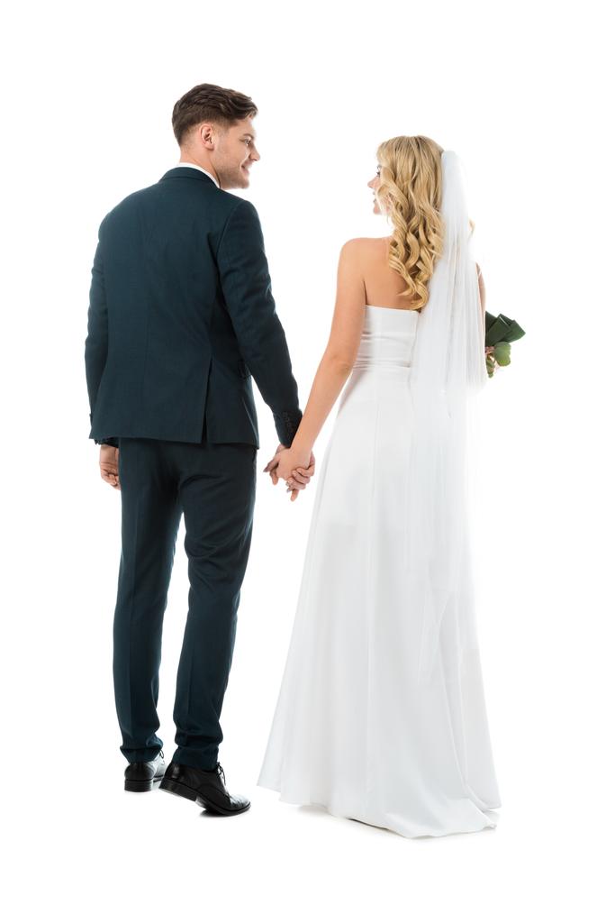 задний вид невесты в белом свадебном платье и жениха в черном костюме изолированы на белом
 - Фото, изображение