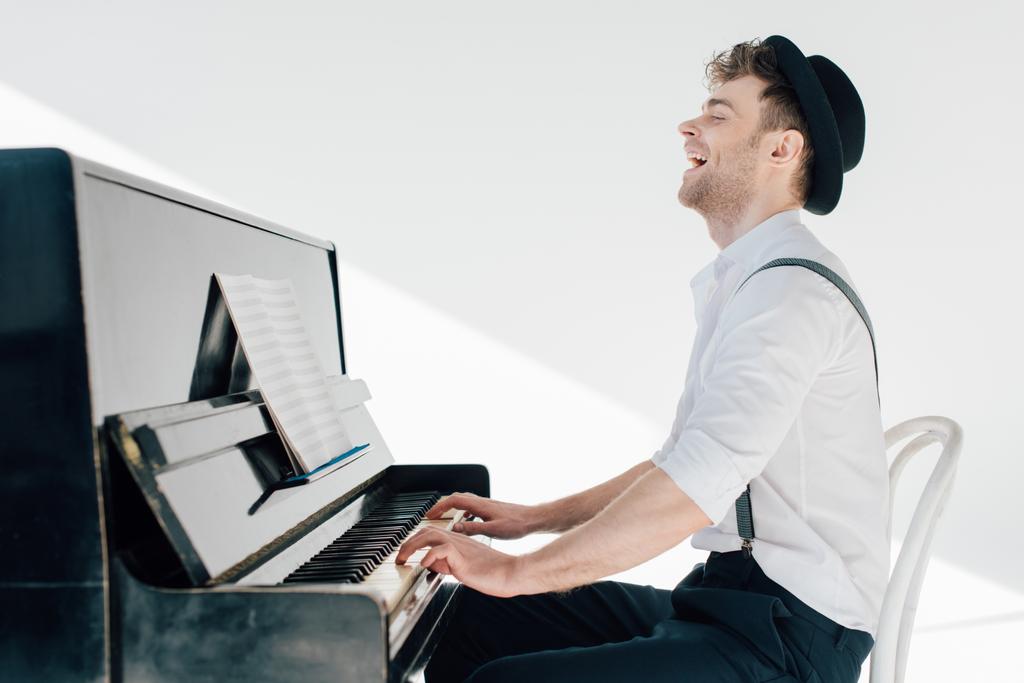 podekscytowany pianista w stylowe ubrania gry na fortepianie  - Zdjęcie, obraz