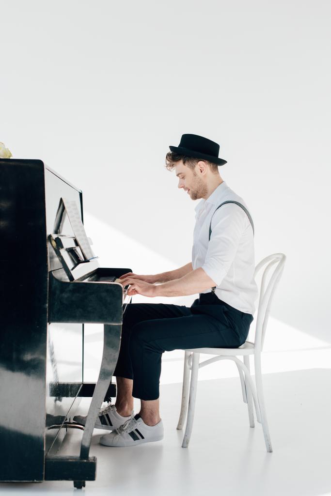 ピアノを弾く流行の服で集中しているピアニスト  - 写真・画像