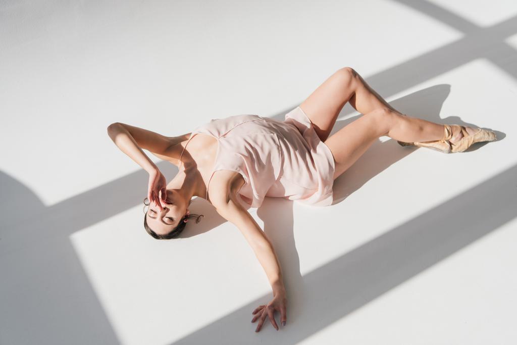elegante bailarina atractiva tumbada en el suelo a la luz del sol
  - Foto, imagen