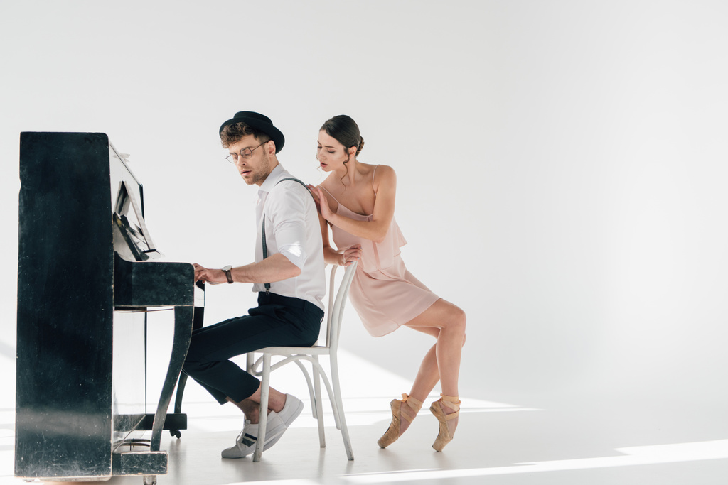 atractiva bailarina tocando apuesto músico tocando el piano
  - Foto, imagen