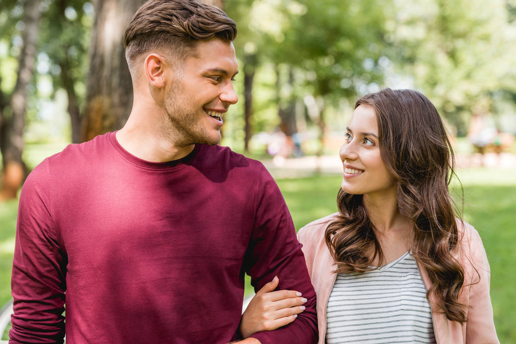 coppia allegra che si guarda mentre sorride nel parco
 - Foto, immagini
