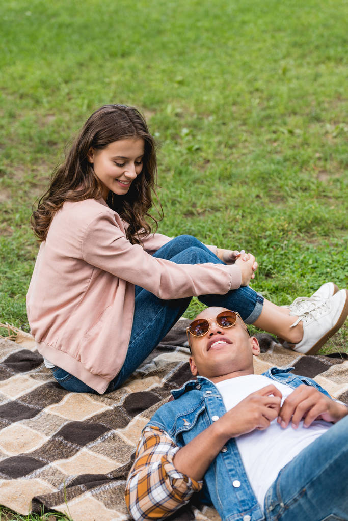 atraktivní dívka, při pohledu na americký přítel ležet na dece v parku - Fotografie, Obrázek