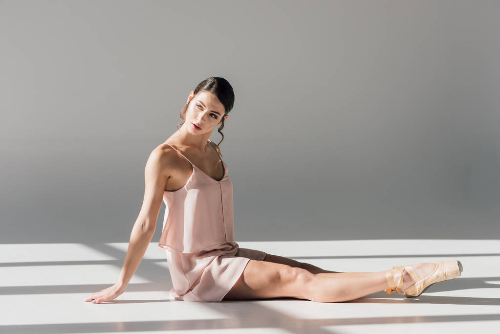 attractive ballerina in pink dress sitting on floor in sunlight  - Photo, Image