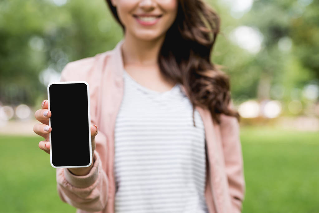 selective focus of cheerful girl holding smartphone with blank screen  - Photo, Image