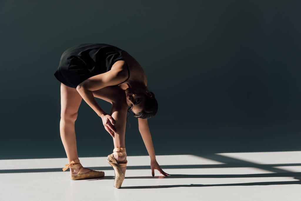 beautiful young ballerina  stretching in black dress - Photo, Image