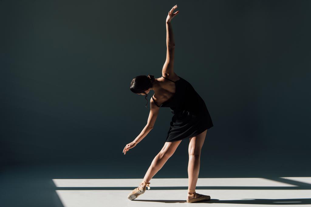ελκυστική νεαρή μπαλαρίνα χορεύει σε μαύρο φόρεμα   - Φωτογραφία, εικόνα