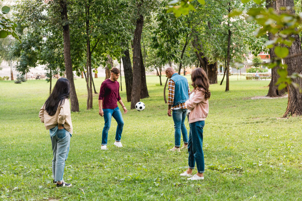 joyeux groupe multiculturel d'amis debout dans le parc près du football
 - Photo, image