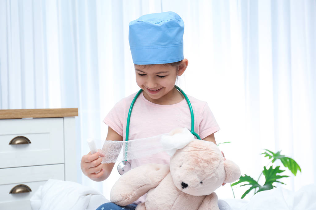 Söpö lapsi leikkii lääkäriä täytetyllä lelulla sairaalaosastolla
 - Valokuva, kuva