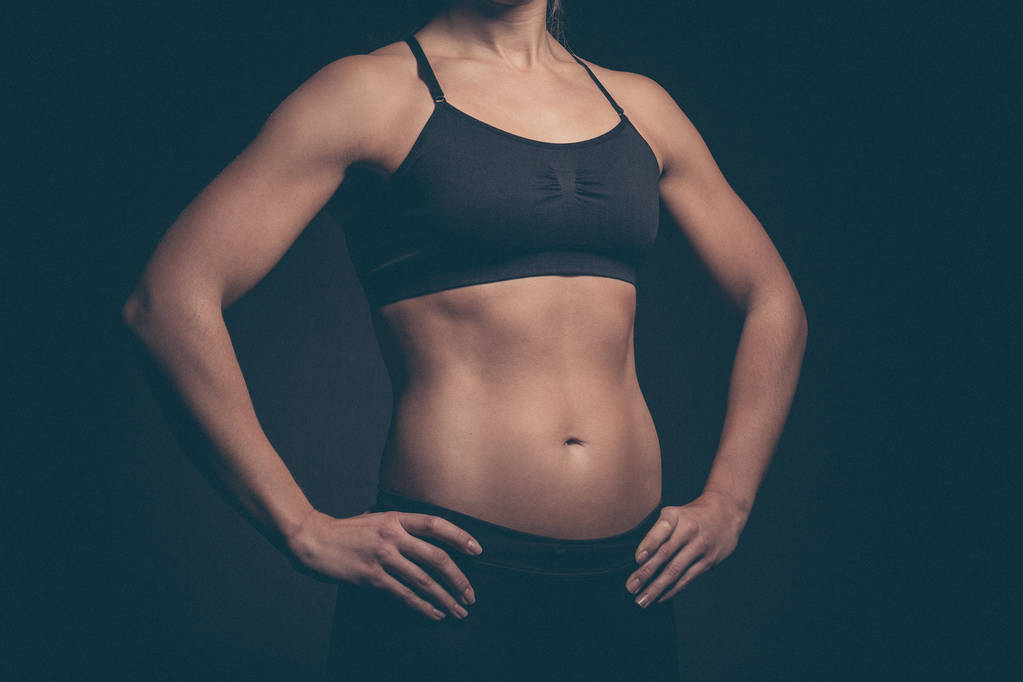 Молода спортивна жінка на темному тлі
 - Фото, зображення