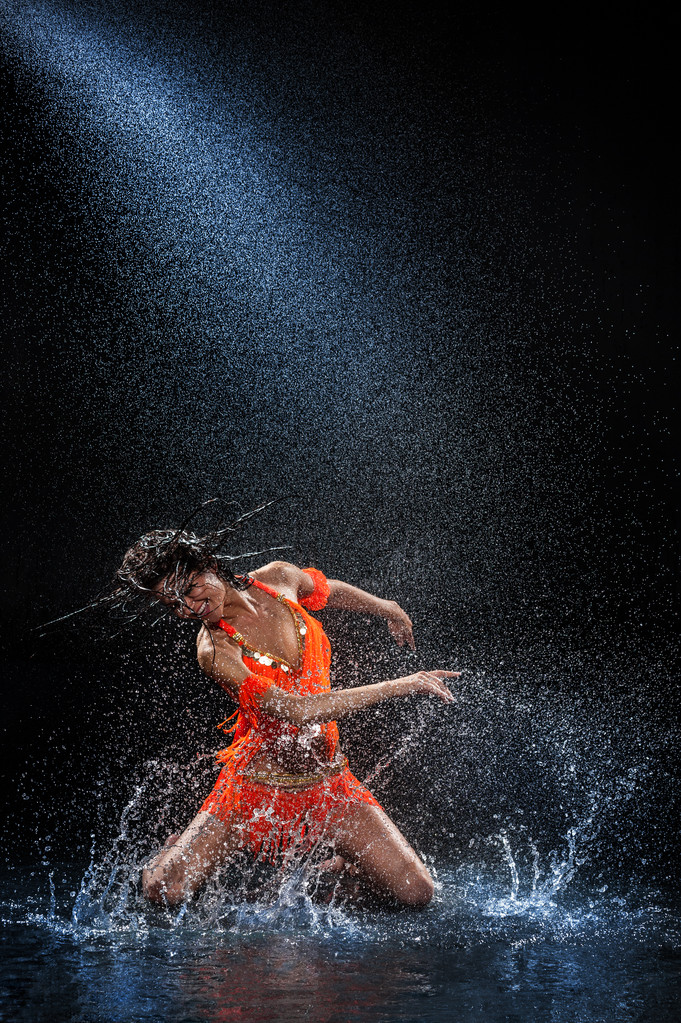 Turuncu elbiseli yağmur altında dans kadın. Stüdyo - Fotoğraf, Görsel