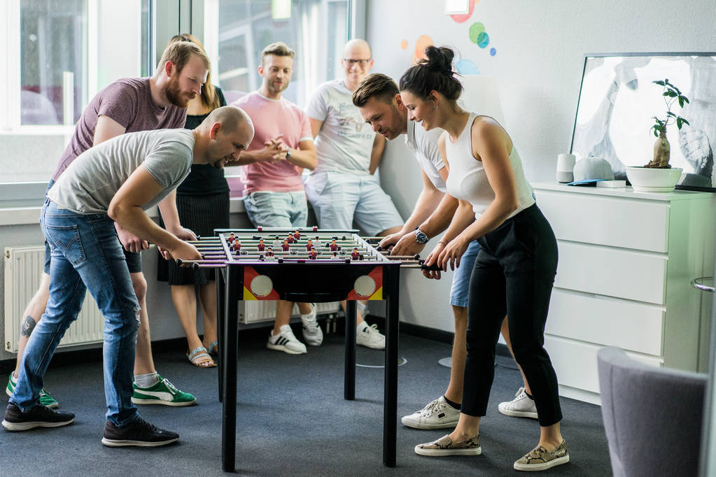 gerentes felices jugando futbolín en la oficina y divertirse juntos
 - Foto, Imagen
