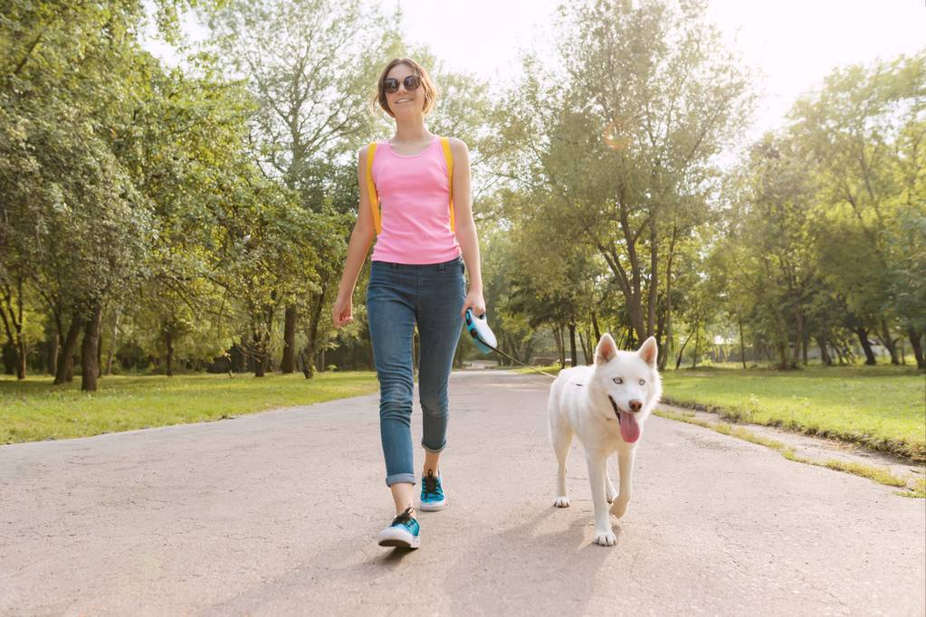 Nuori teini tyttö kävelee koiran kanssa puistossa
 - Valokuva, kuva