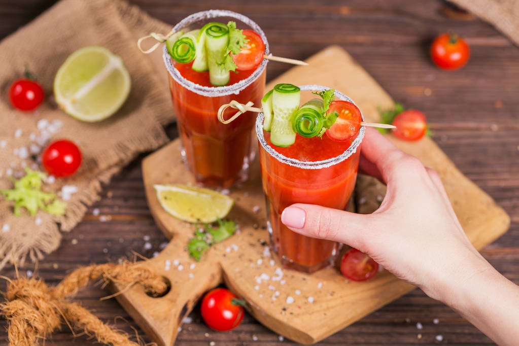 Дві склянки томатного соку, прикрашені свіжими помідорами, огірок
 - Фото, зображення