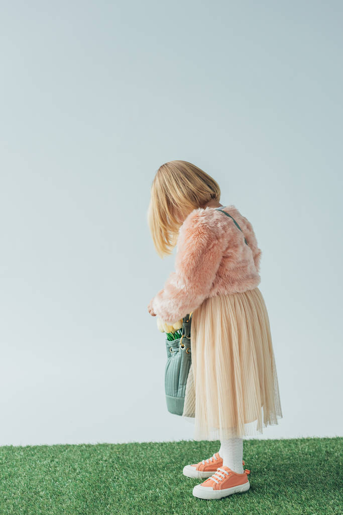 puolella näkymä tyttö tilalla laukku valkoinen tulppaanit eristetty harmaa
  - Valokuva, kuva