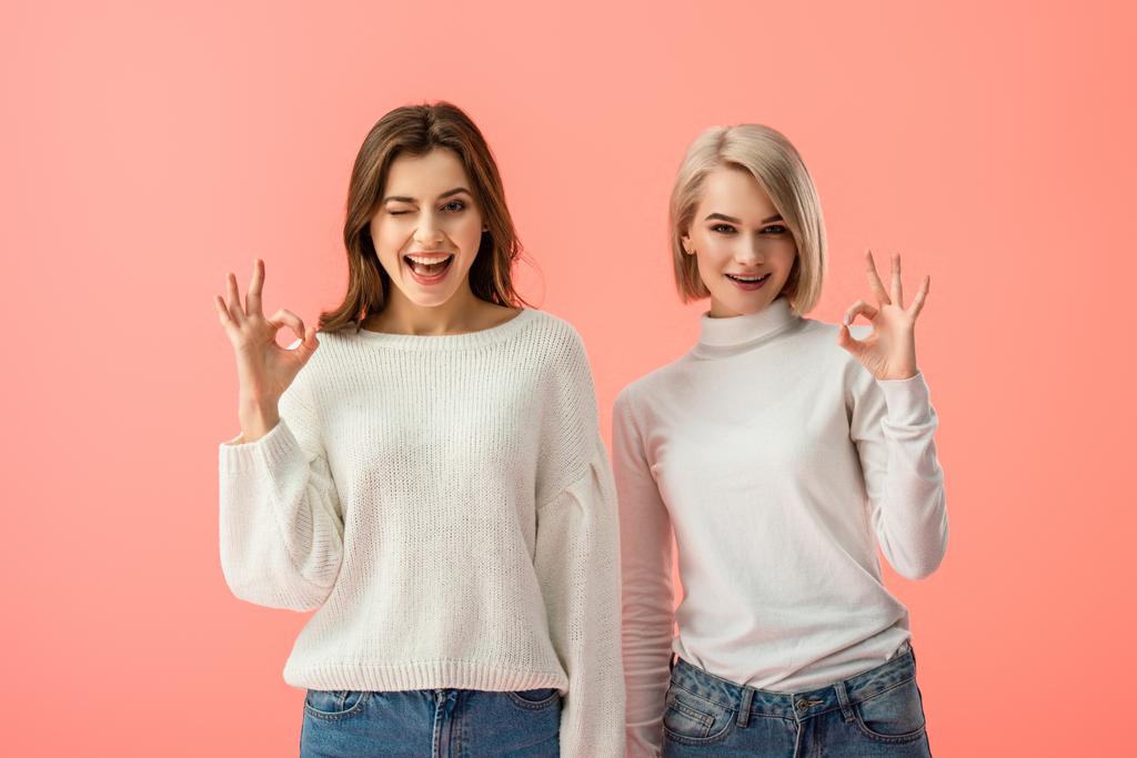 attraente bruna e bionda ragazze mostrando ok segno isolato su rosa
  - Foto, immagini