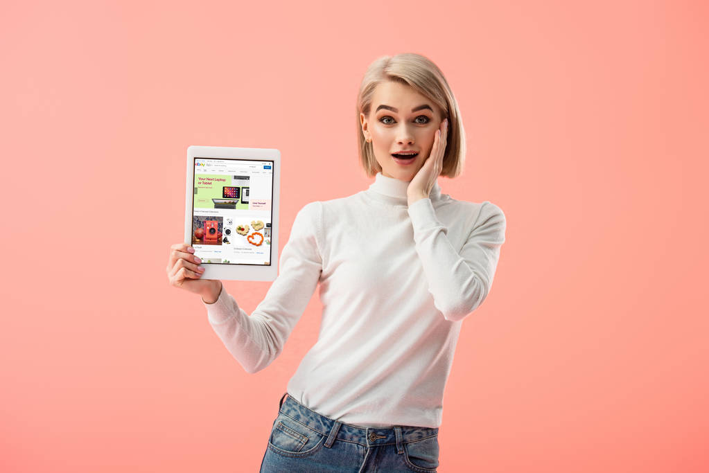 surprise femme blonde tenant tablette numérique avec application ebay à l'écran isolé sur rose
  - Photo, image