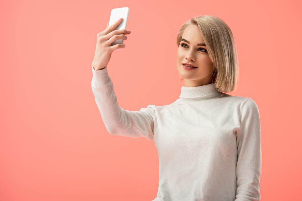 mulher loira alegre tomando selfie no smartphone isolado no rosa
  - Foto, Imagem